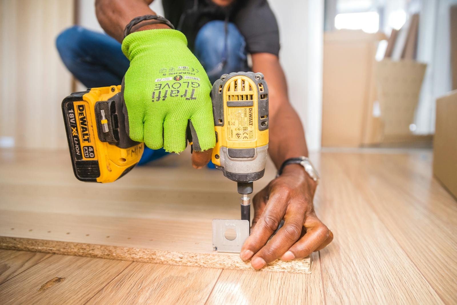 Contacto Raul Andrades Puerto Real Man using a power drill for home improvement on a wooden floor with precision.